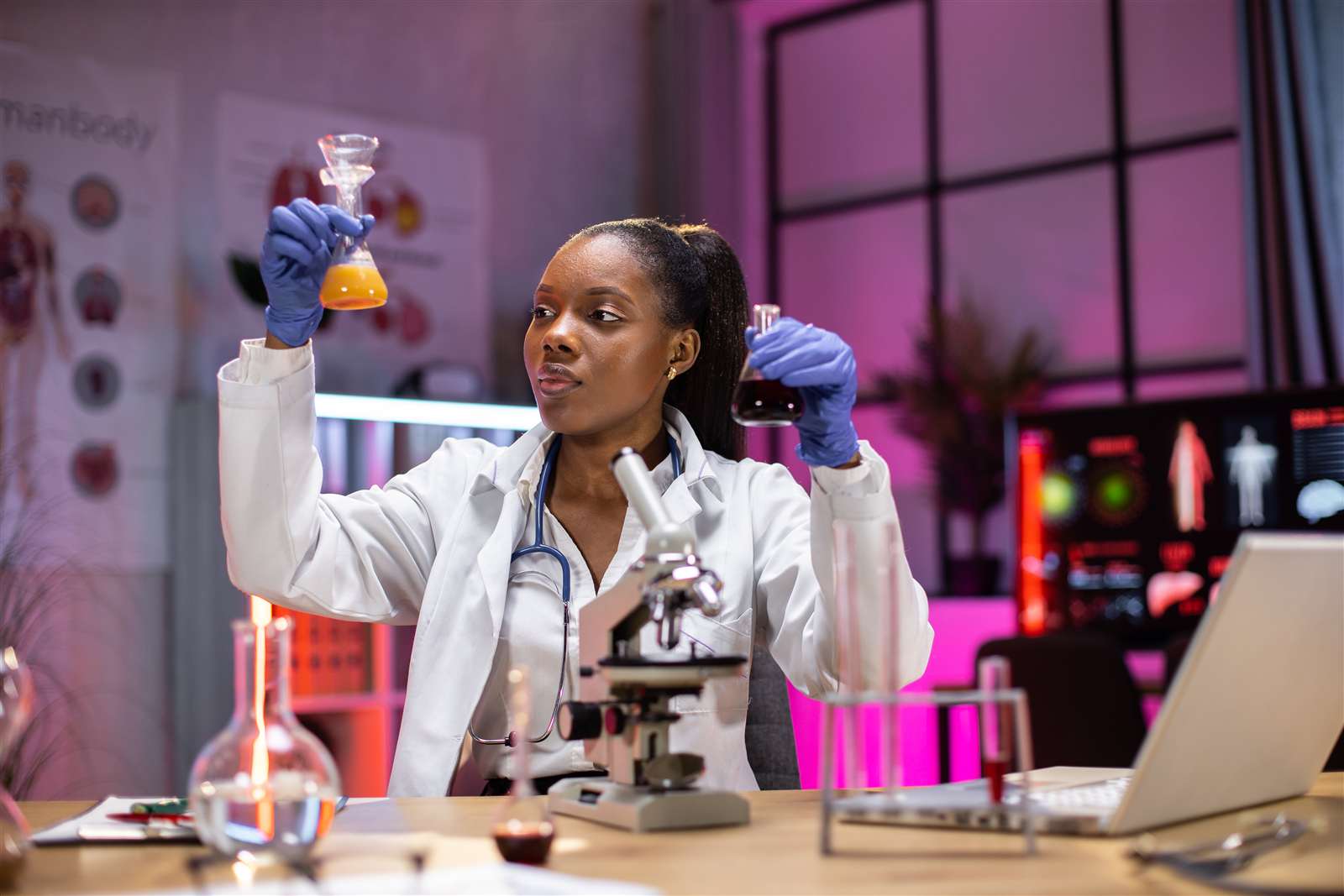 Woman scientist holding beakers with lab equipment
